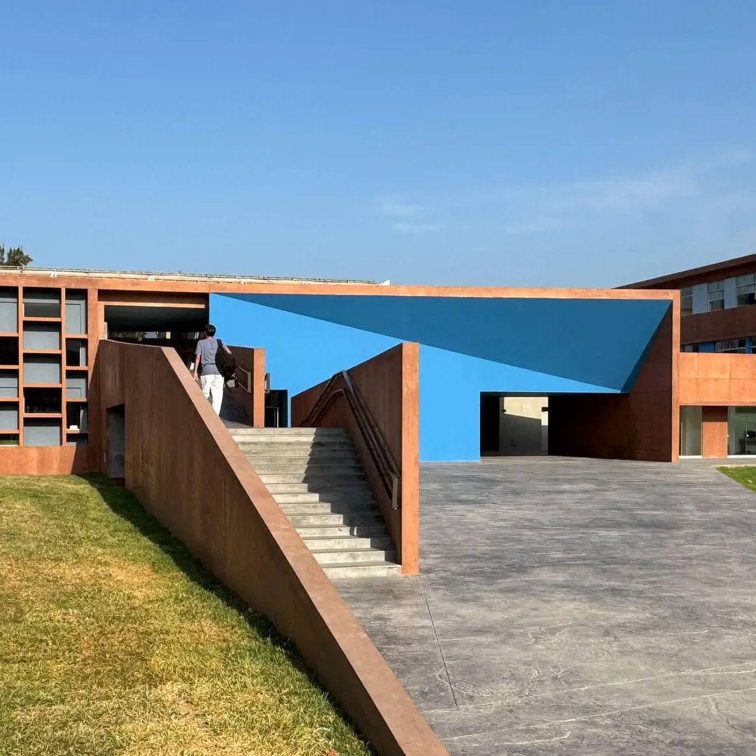 Estructura moderna con elementos geométricos de colores en un entorno verde