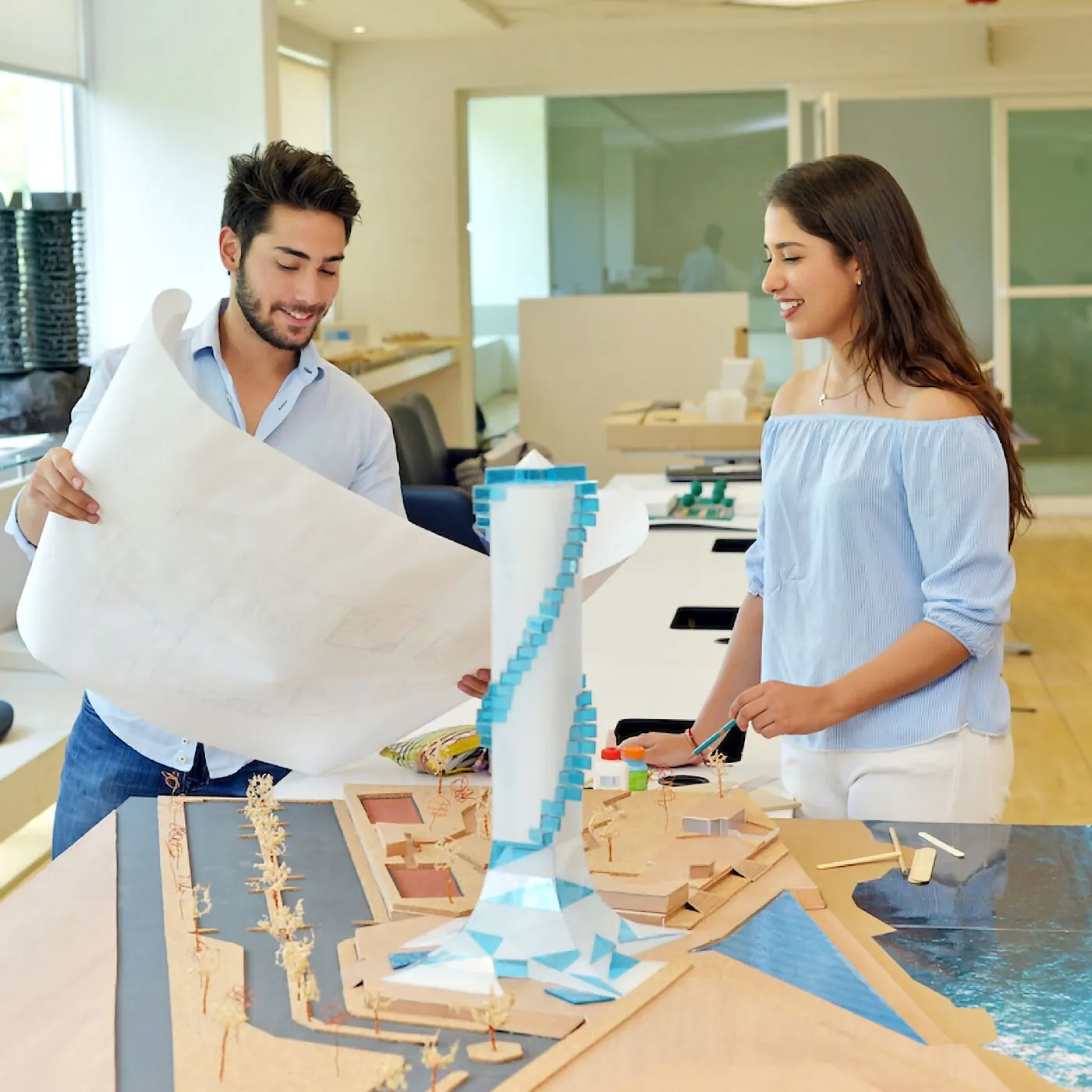 Arquitectos trabajando en maqueta de rascacielos.